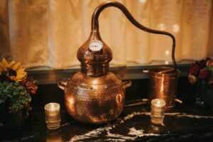 a brown pot with clock on black and white surface beside candles